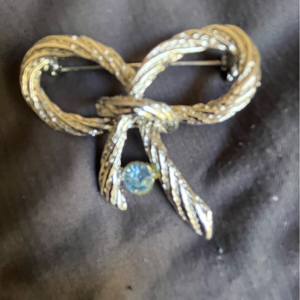 Pin bow broach with light blue stone